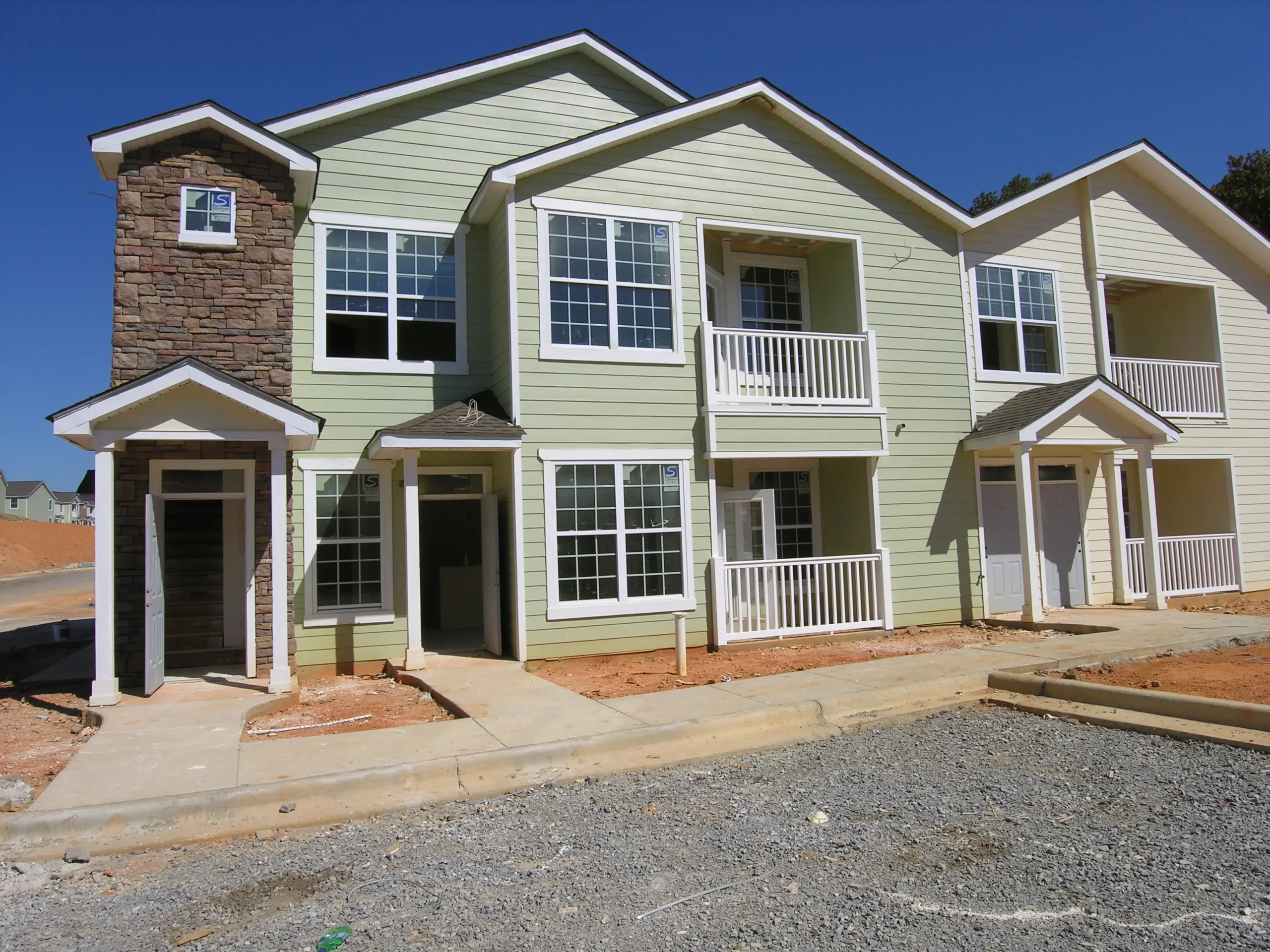 New build multi-family rental property with grey brick and green vinyl siding